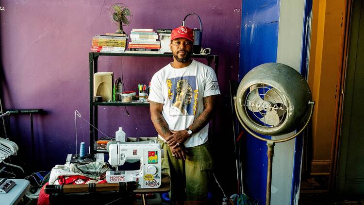 Emanuel “Manny” Edwards stands next to his sewing machine.