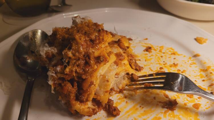 A half-eaten slice of lasagne