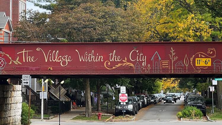 A painted viaduct over Roscoe Street that reads "The Village Within the City."