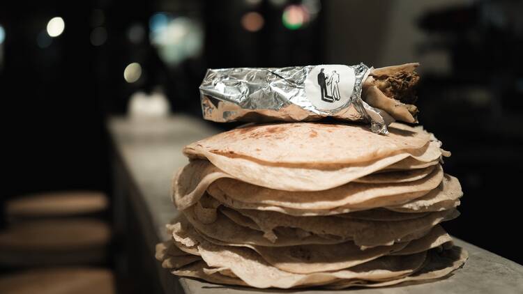 A stack of tortillas with a burrito on top