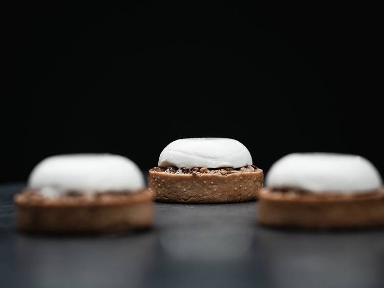 Vato Three pecan tarts on a black table