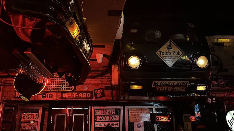 Interior of Toto’s Pub featuring its signature suspended cars and vintage décor