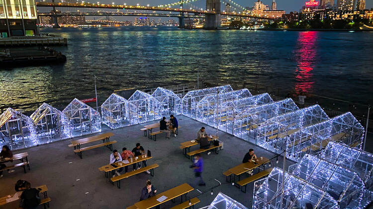 Benches and enclosed heated igloos on the pier 15 walkway overlooking the brooklyn bridge Benches and enclosed heated igloos on the pier 15 walkway overlooking the brooklyn bridge