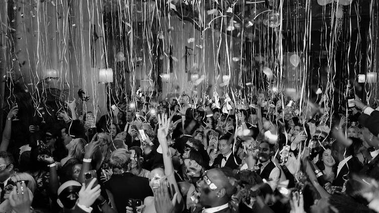The Soho Grand NYE ball - streamers coming down with people dressed in formal attire and masks The Soho Grand NYE ball - streamers coming down with people dressed in formal attire and masks
