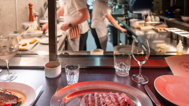 Entrecote pihvi Brera ravintolan keittiön tiskillä, takana näkyy kokkeja keittiössä