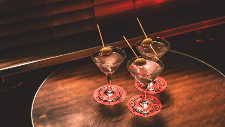 Three martinis with olives on a table