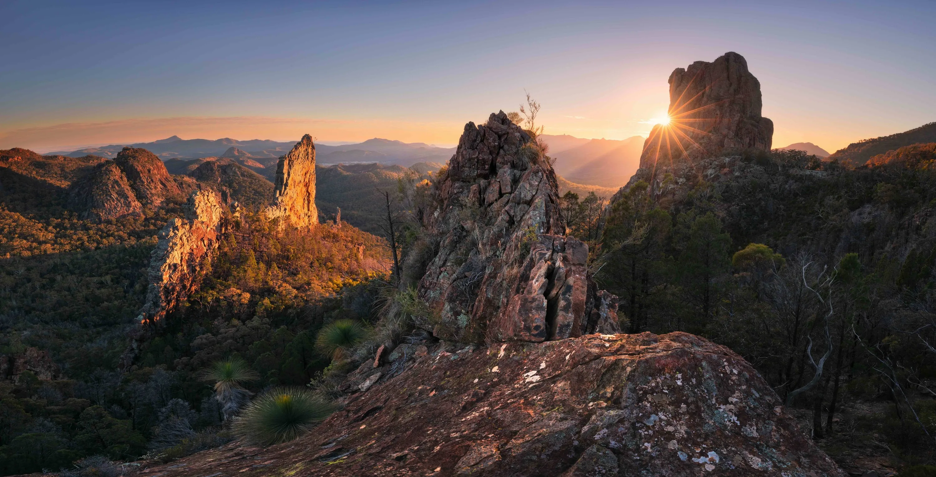 Sun rising over the Breadknife rock formation in Warrumbungle National Park.