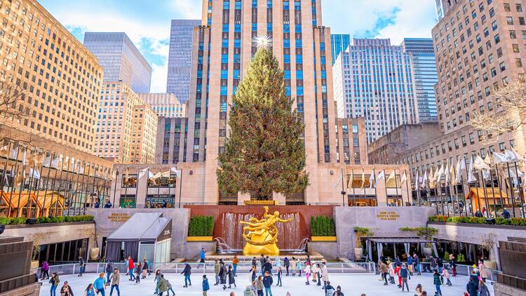 People ice skate in the Rink at Rockefeller Center under Christmas tree