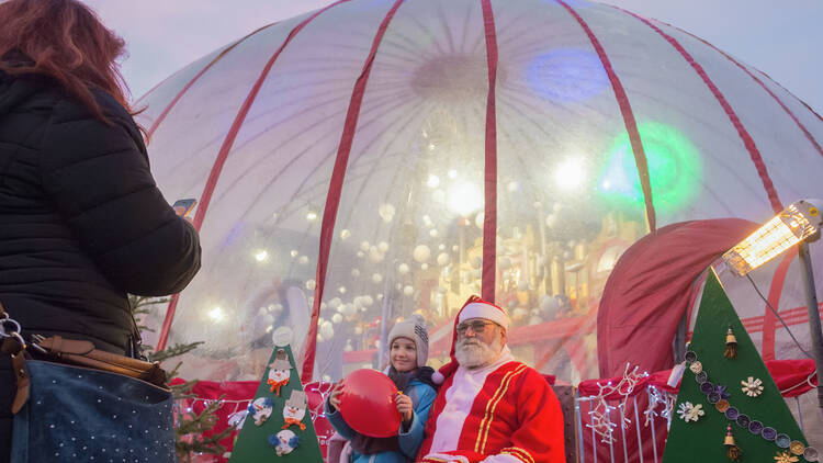 A finn Mikulás a MikulásGyár igluja előtt gyerekekkel találkozik