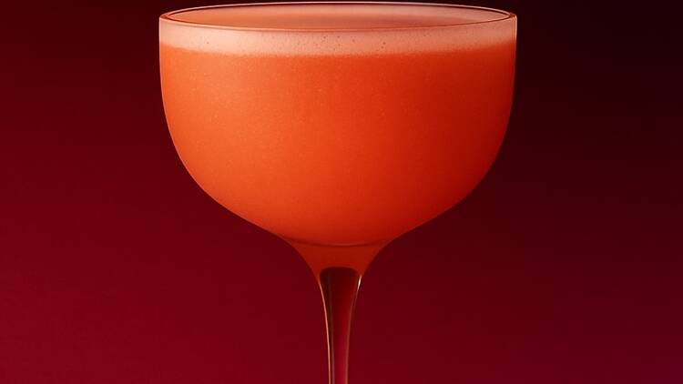 A pink cocktail in a coupe glass A pink cocktail in a coupe glass