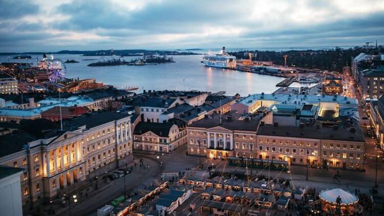 Talvinen iltanäkymä Helsingin Kauppatorilta ja Torikortteleista, taustalla Itämeri ja saapuva risteilyalus.