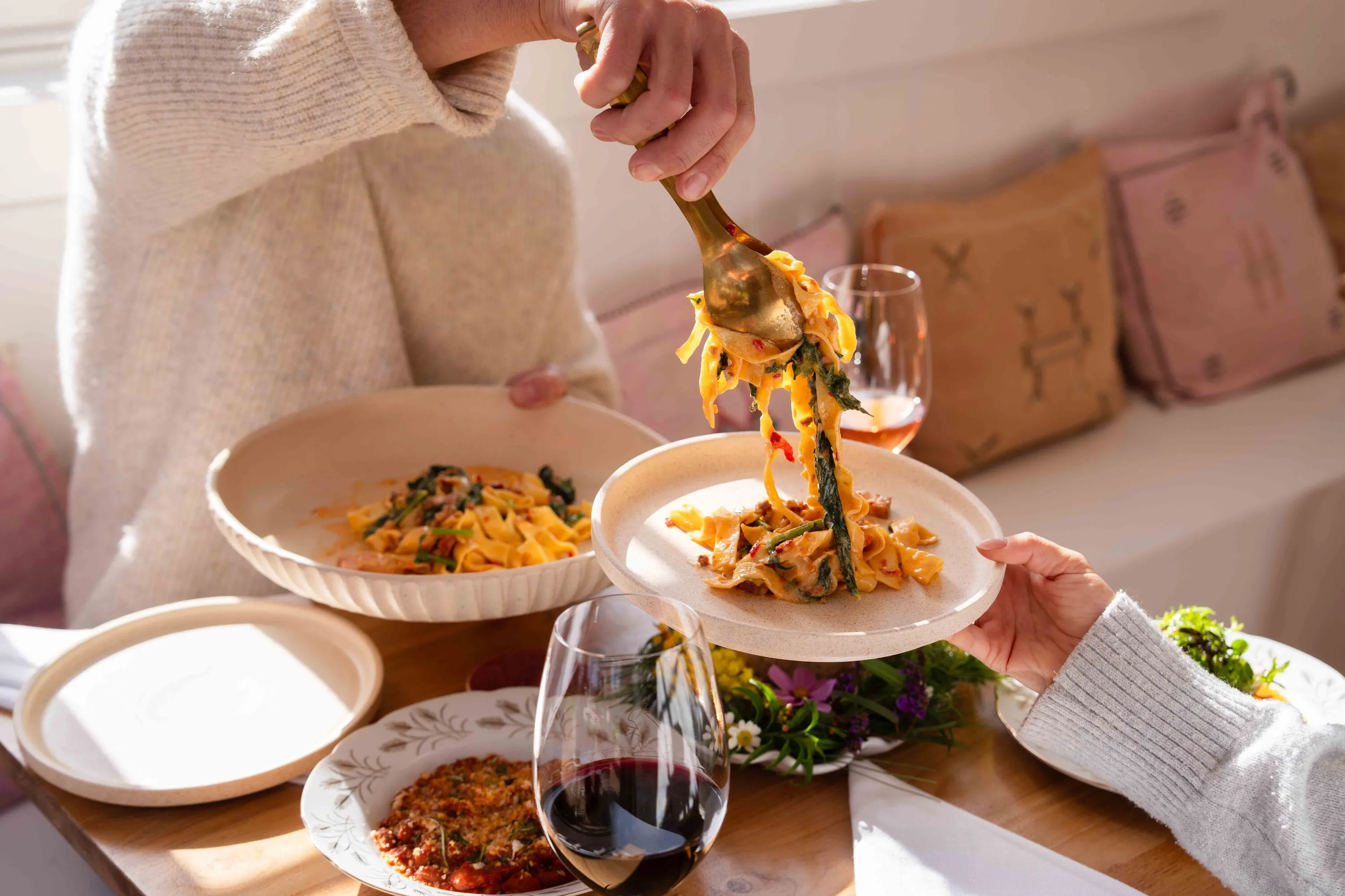 People having pasta at dining table