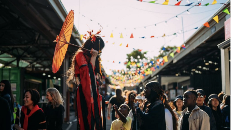 Queen Victoria Summer Night Market performer on stilts at outdoor market
