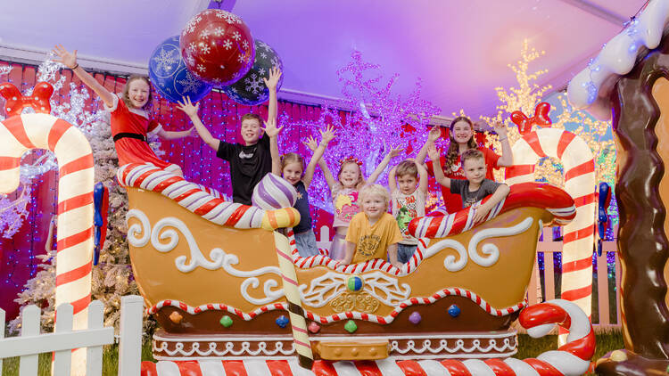 Kids sitting in a sleigh.