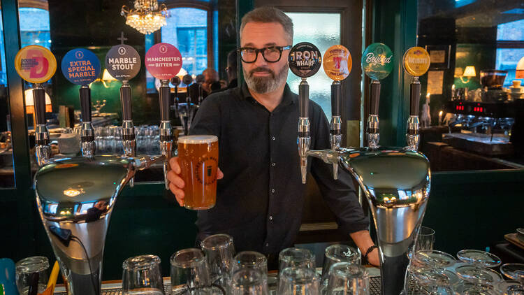 Aki Arjola ojentaa tuoppia The Tart ravintolan baaritiskin takaa Aki Arjola ojentaa tuoppia The Tart ravintolan baaritiskin takaa