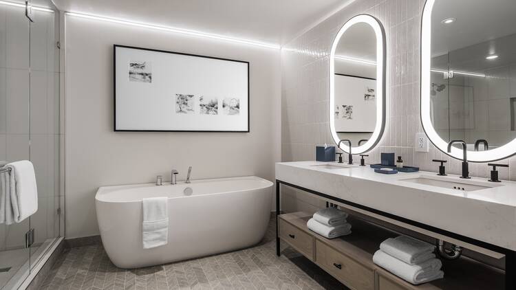 The inside of a hotel bathroom showing a bathtub and sinks. The inside of a hotel bathroom showing a bathtub and sinks.
