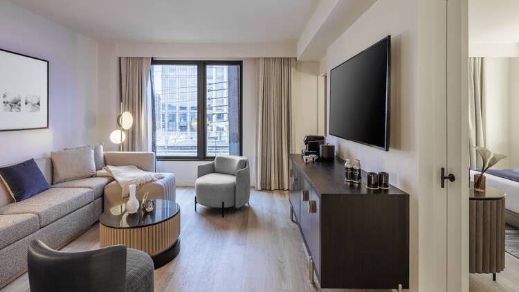 The living room area of a hotel room with a couch and TV. The living room area of a hotel room with a couch and TV.