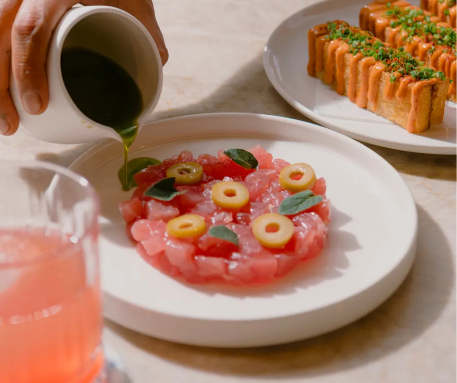 Dressing being pured on Yellowfin tuna tartare at Pier Dining in Sydney