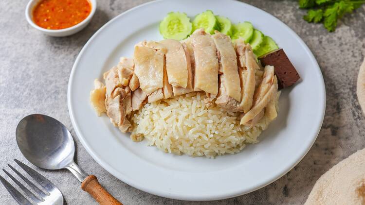 Chicken rice Chicken and rice with coriander and cucumber with sauce and soup in a white plate, hainanese chicken rice, thai called khao man gai, asian food, thai food