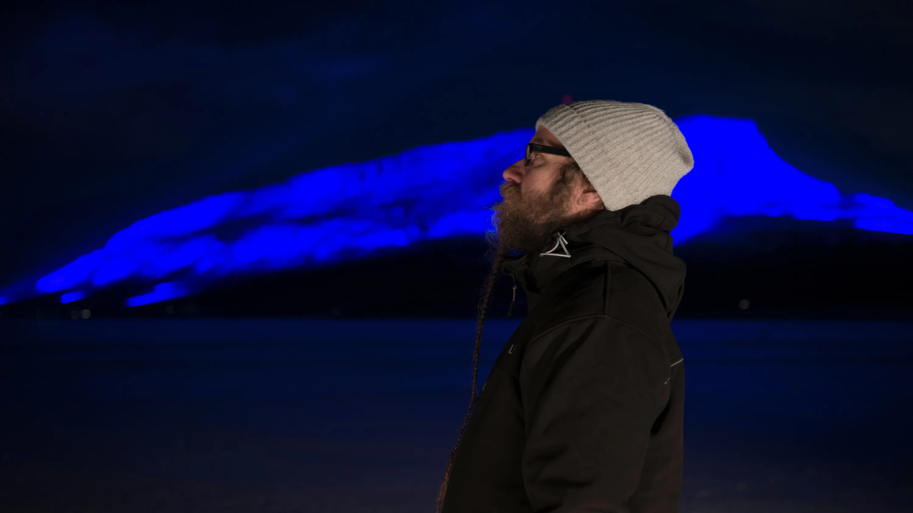 Man in front of blue light installation
