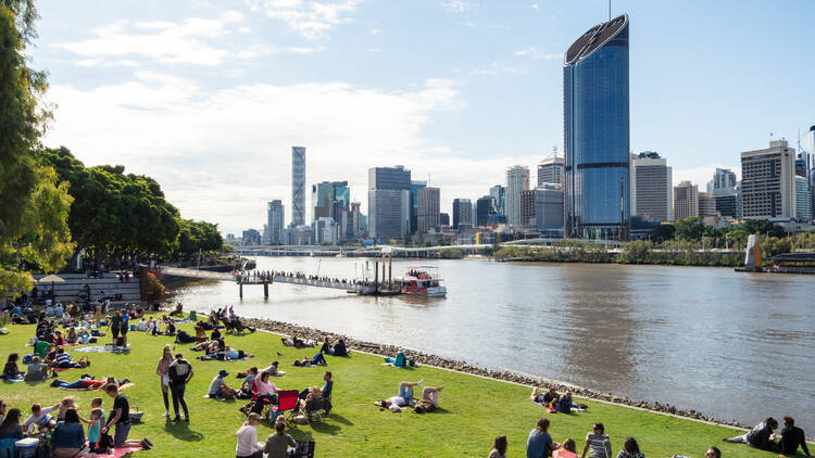Brisbane, Australia with people hanging out on the grass by the river Brisbane, Australia with people hanging out on the grass by the river