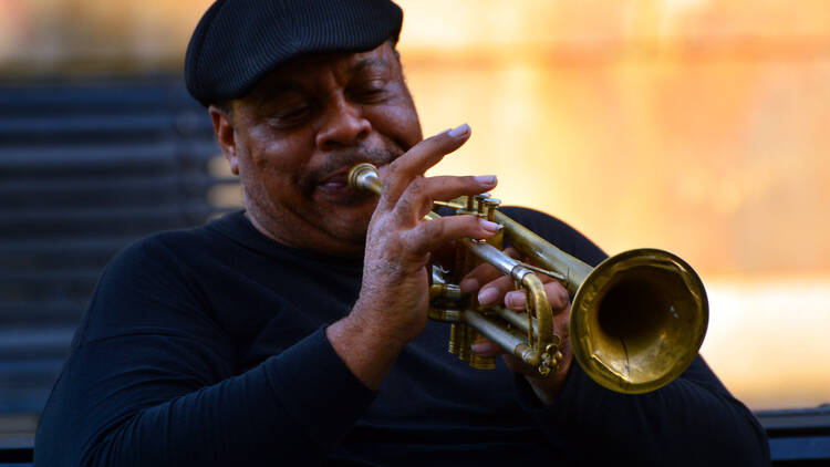 Jazz trumpeter entertaining in a park A jazz musician plays a trumpet solo at a public performance