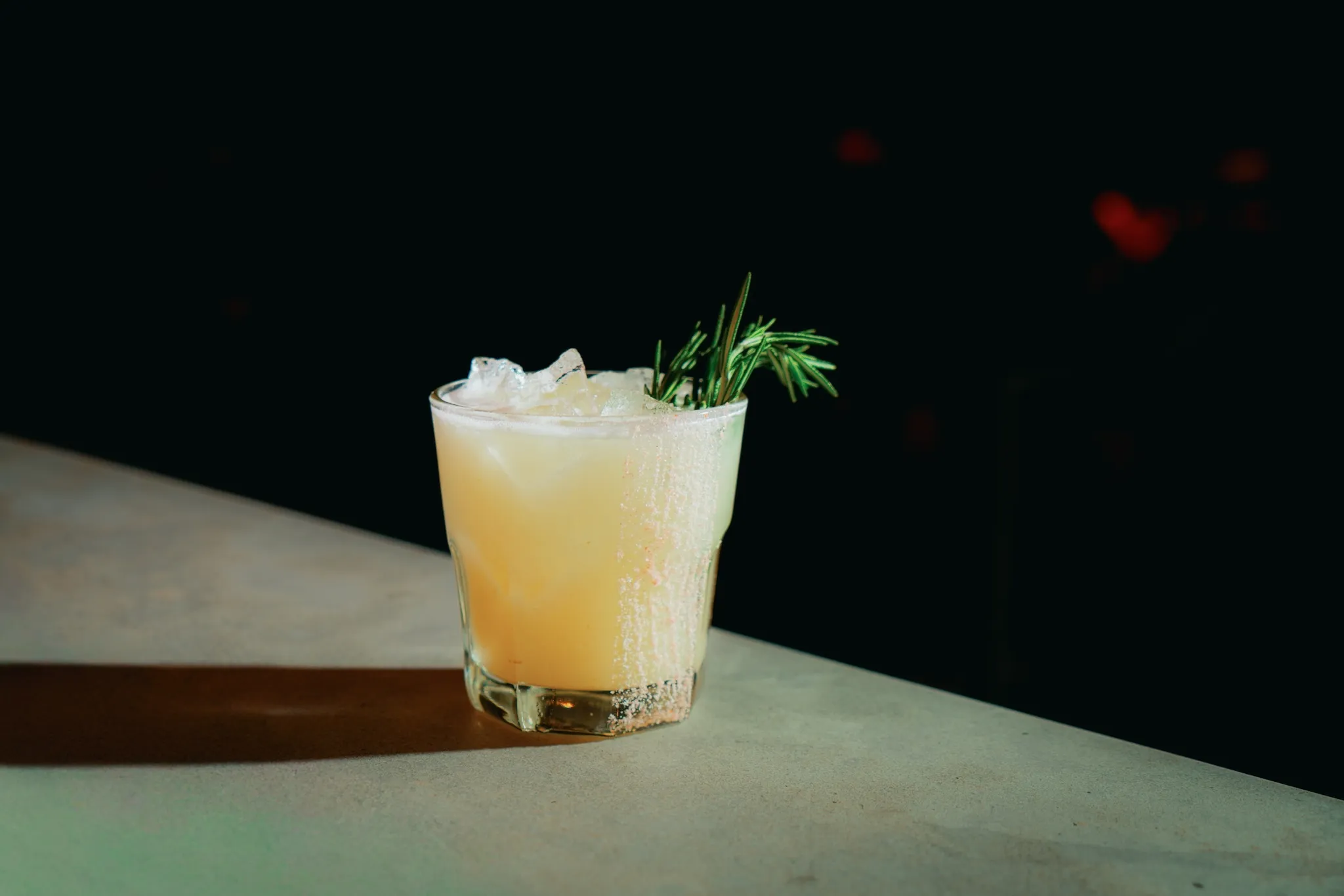 A cocktail with a rosemary sprig