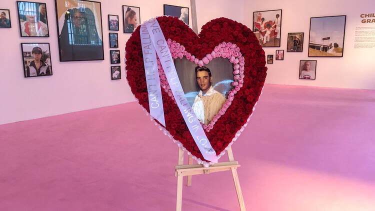 Photo of Elvis surrounded by a heart-shape wreath of flowers Photo of Elvis framed by a heart-shape wreath of flowers