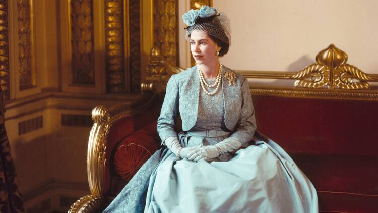 Queen Elizabeth dressed in a blue gown and matching jacket for Princess Margaret’s wedding