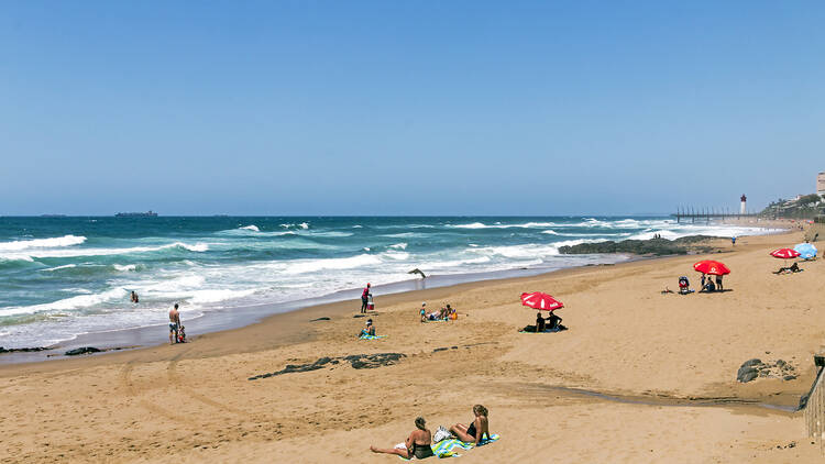  Coastal landscape of many unknown people on early morning visit to uMhlanga beach in Durban, South Africa