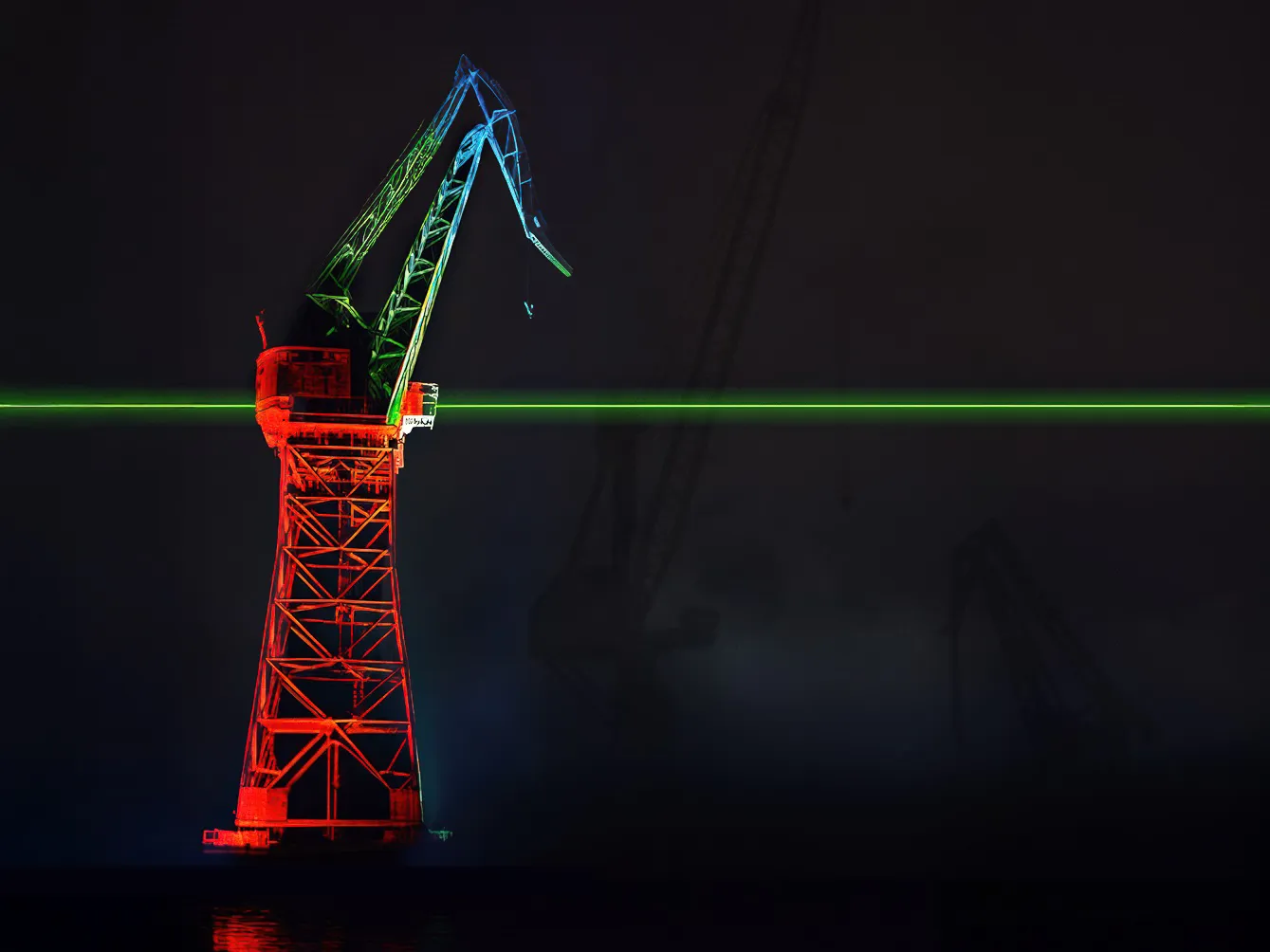 Valolla punaiseksi v&auml;rj&auml;tty nostokurki, jonka l&auml;pi menee vihre&auml; laserviiva