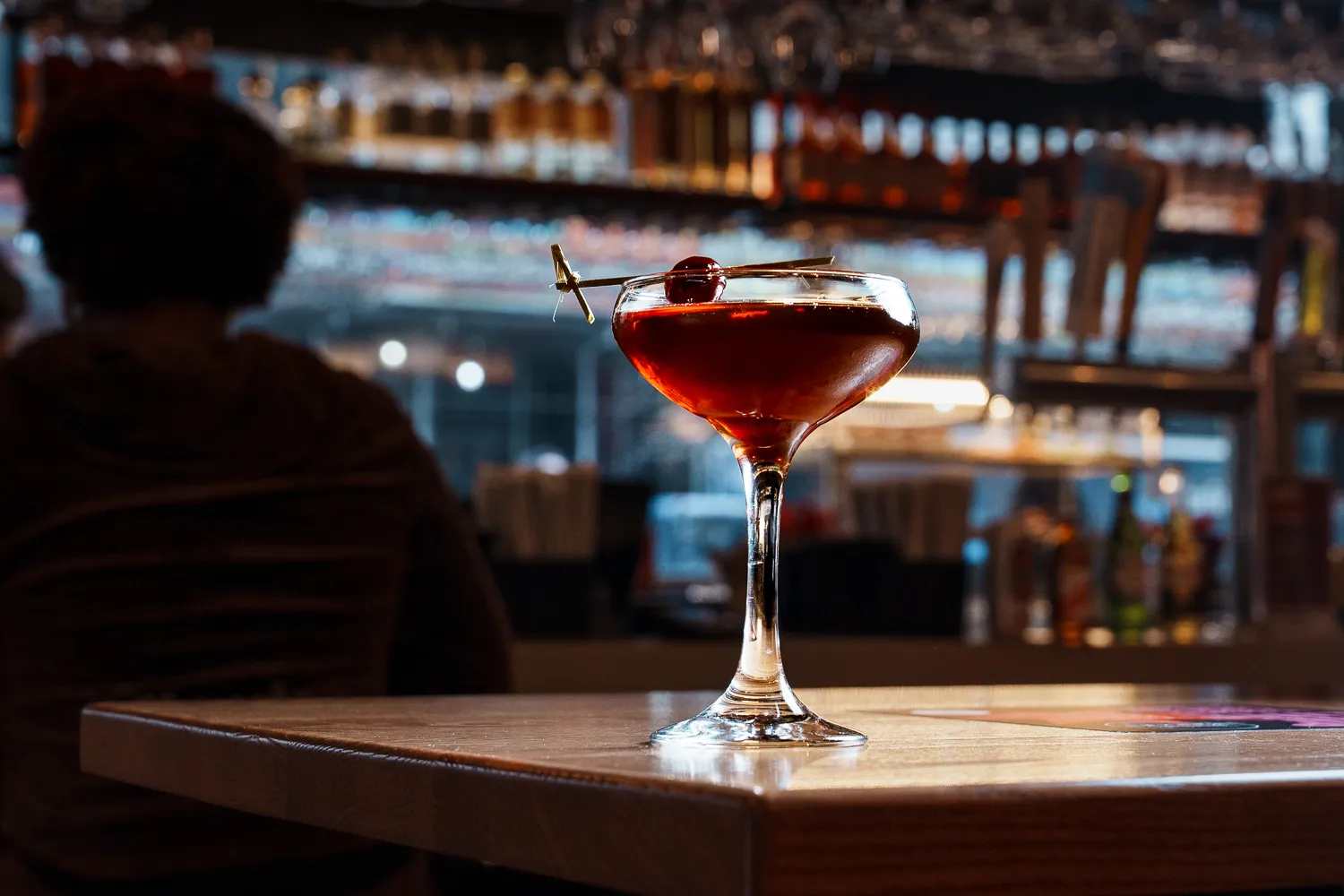 A cocktail with a cherry skewer on top