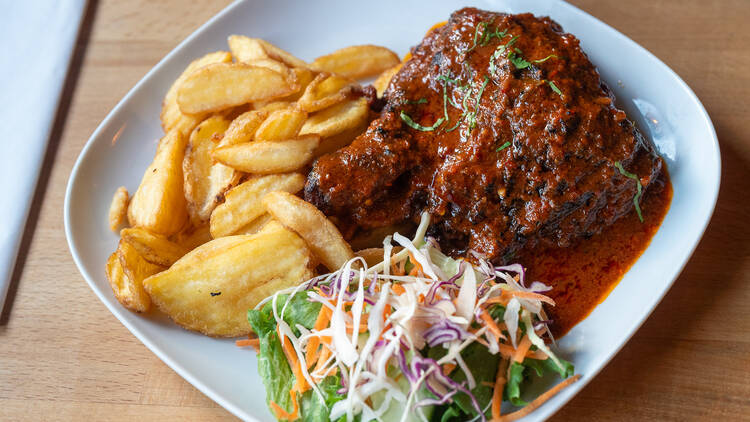 Piri-piri-kanaa ja paistettuja perunoita lautasella portugalilaisessa Wave of Flavors ravintolassa Helsingissä