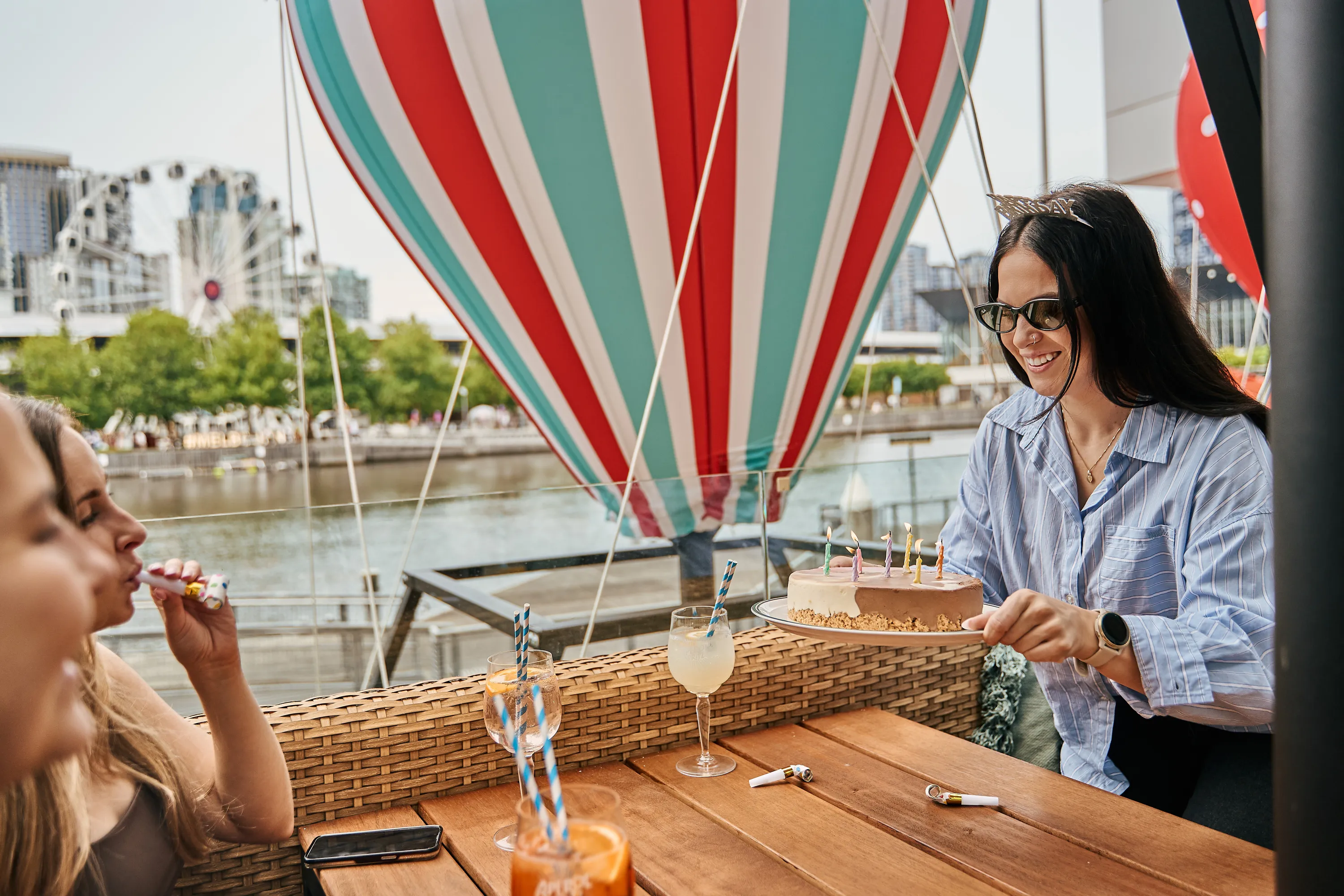 Girl holding a birthday cake and enjoying a celebration with friends.