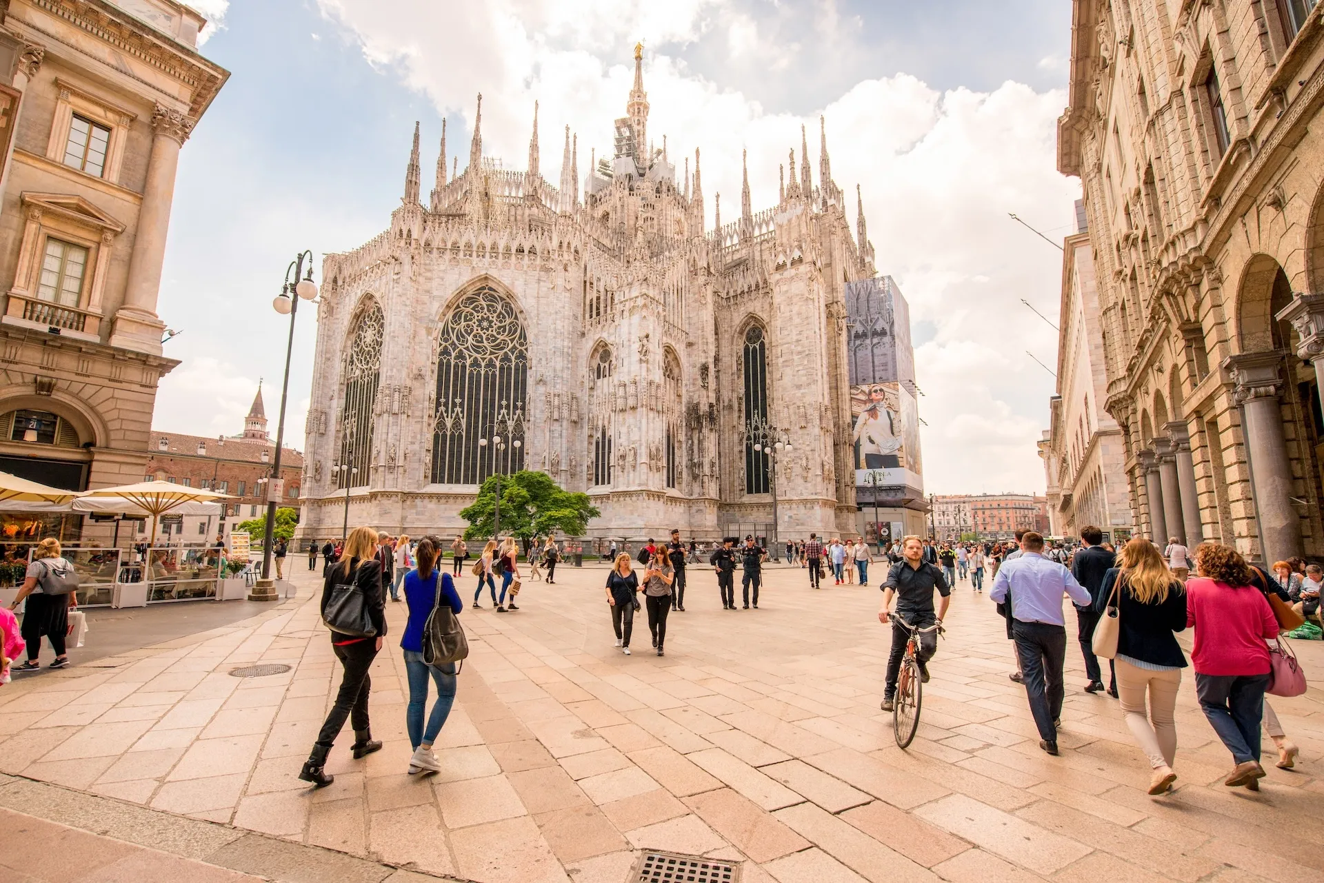  People walk on the square near the famous Duomo cathedral in Milan city in Italy. City life in the center of Milan