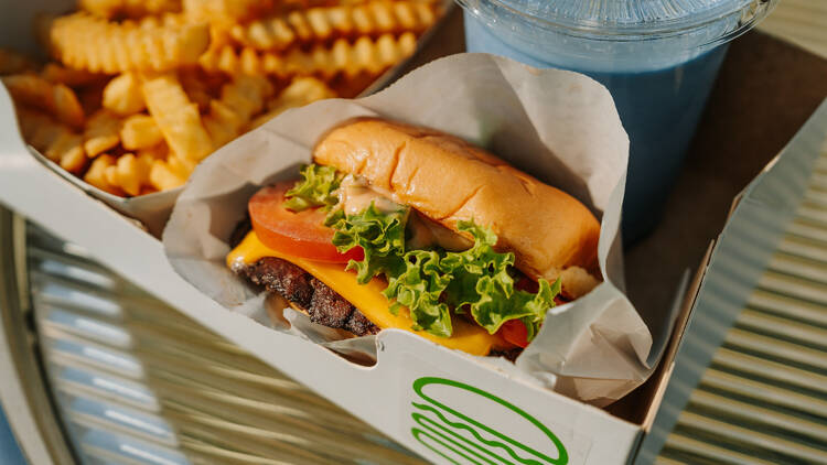 A Shake Shack burger with fries and a drink.