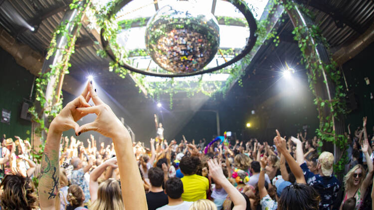 People dancing under a giant disco ball.