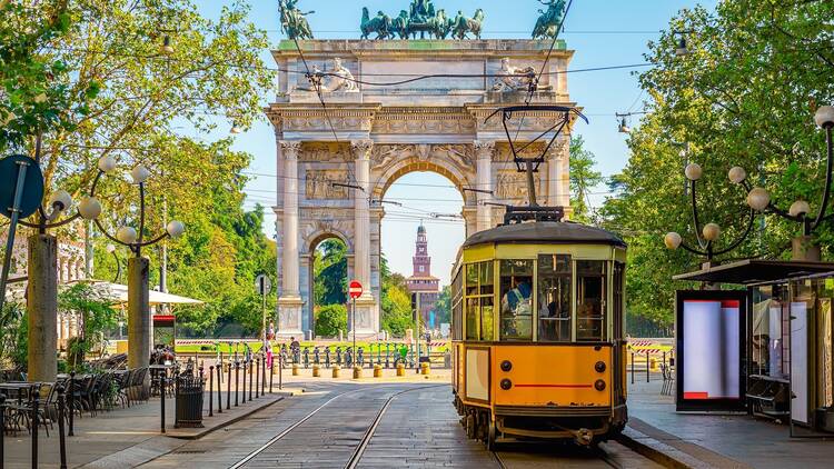 View of the Peace Arch with yellow tram in Milan, Italy