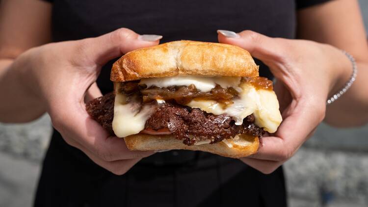 A person holding a smash burger