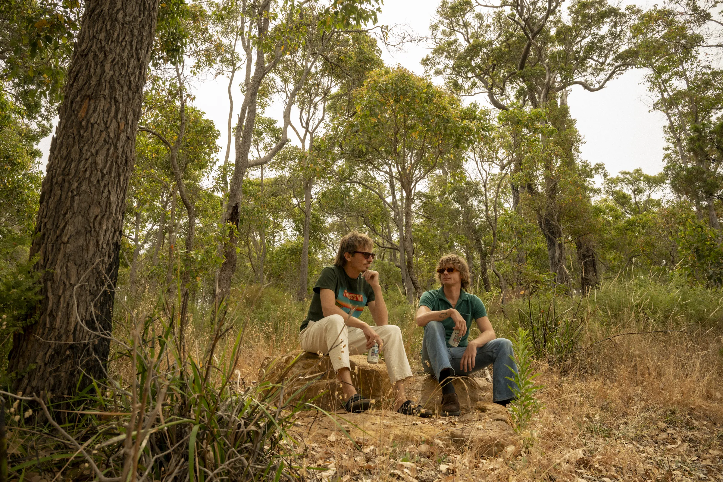 Two men sitting in forest