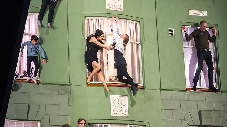 People appear to be hanging from the windows in Leandro Erlich’s art piece at the Amos Rex art museum in Helsinki.