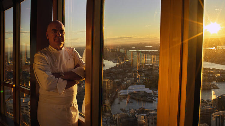 Chef Mark Best standing at a window at sunset