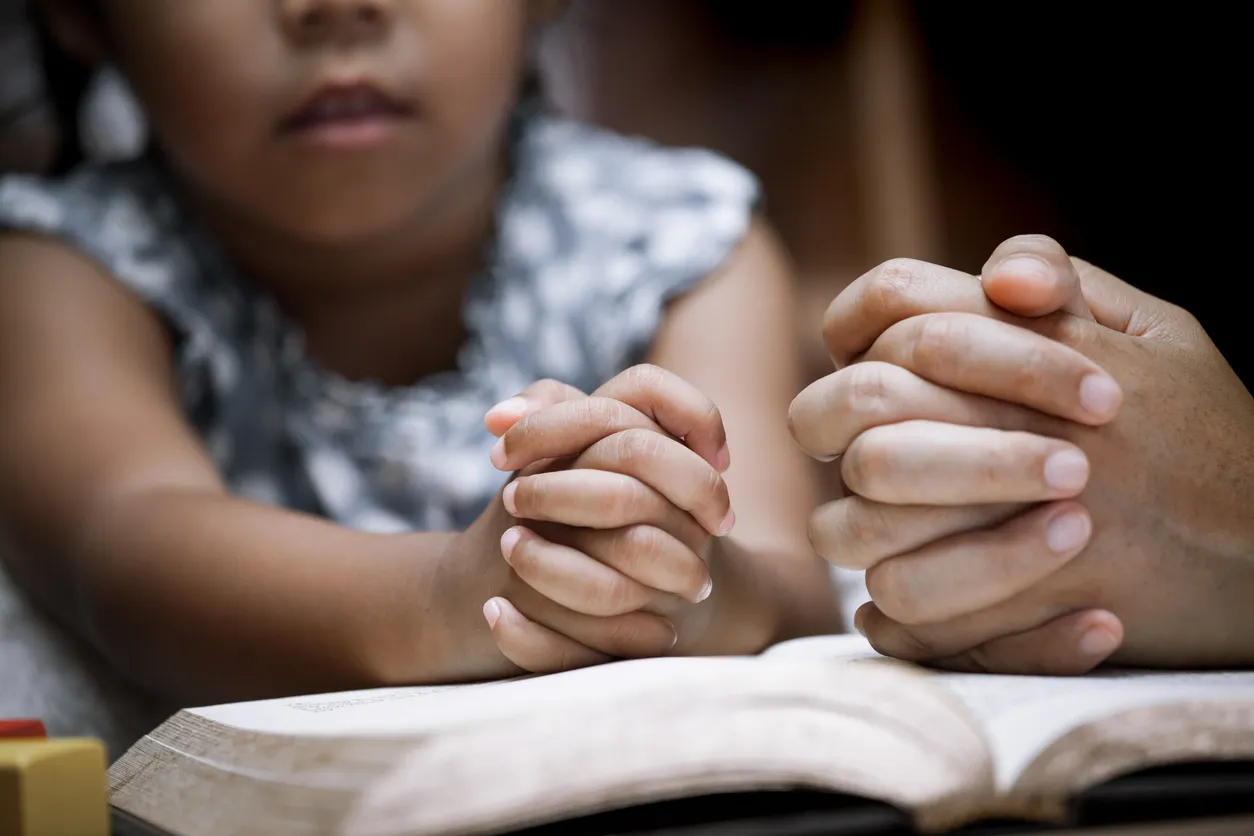 Mother and little girl in prayer