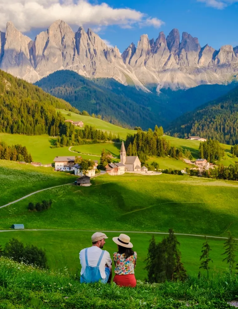 A couple viewing the landscape from Val Di Funes in Italy