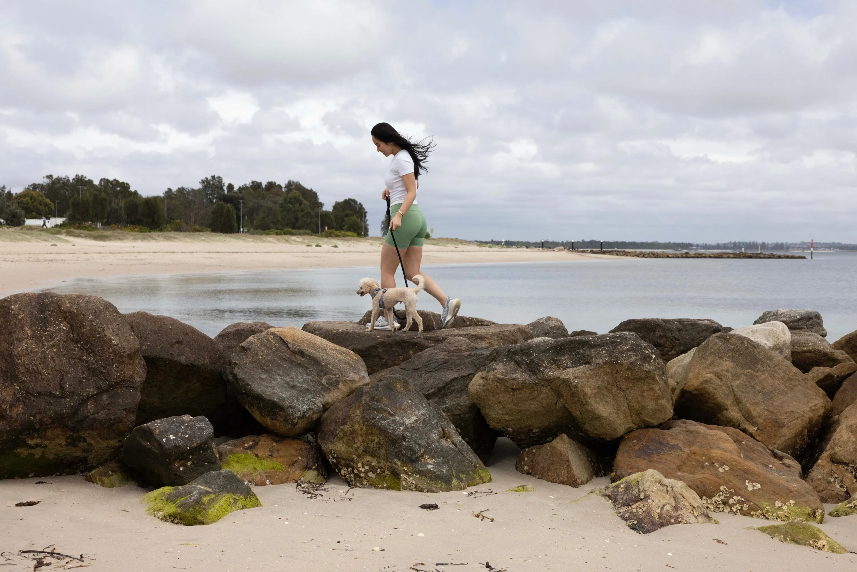 Woman spending a day at the beach with her dog along Kurnell Dog Beach in Kurnell.