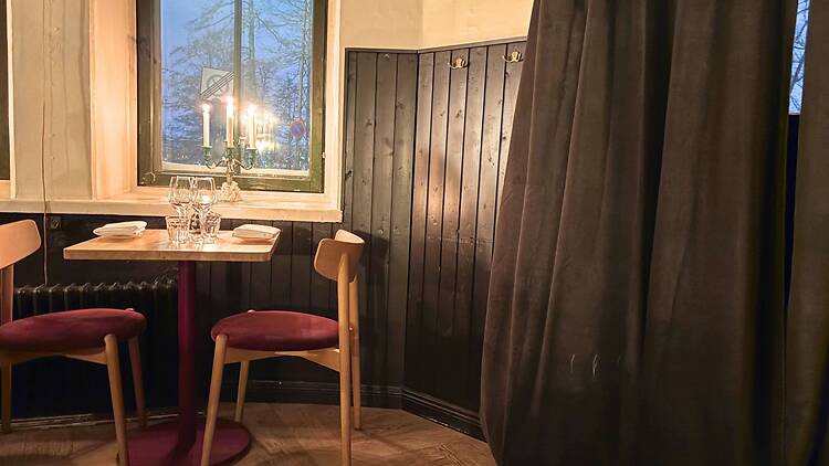 Pieni ja intiimi pöytäpaikka Ravintola Wellamossa, jossa ikkunasta näkyy talvinen Katajanokka.