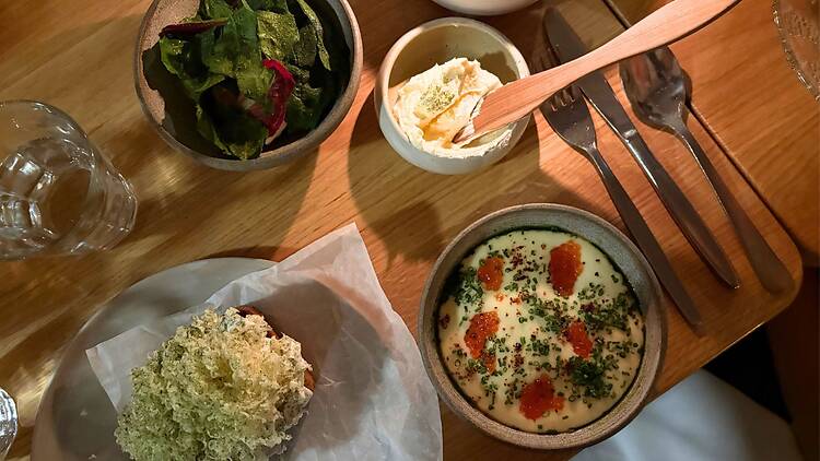 Ravintola Wellamon alkuruokia, kuten mätiä, voita ja tuoretta leipää, kauniisti katettuna.