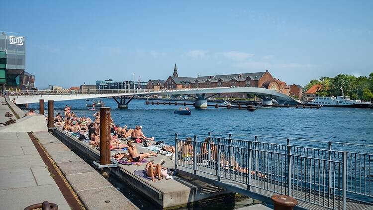 People relaxing on the harbour on a sunny day in Copenhagen People relaxing on the harbour on a sunny day in Copenhagen