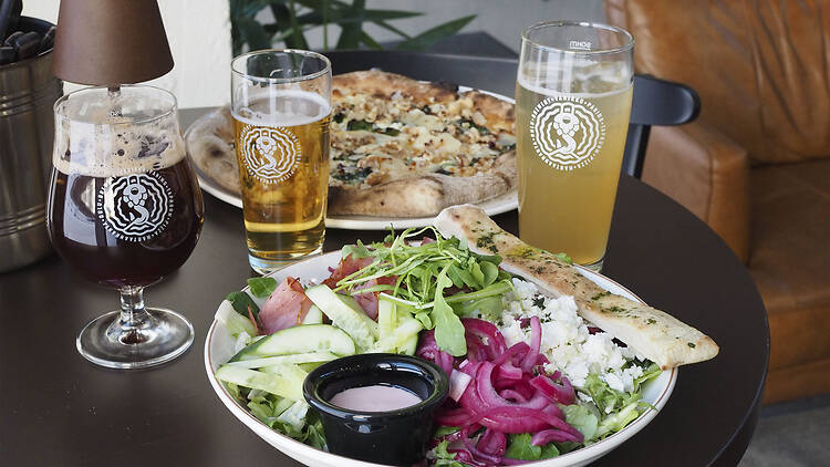 Salaattiannos, pizza ja kolme olutta pöydällä Varikko Panimossa Oulussa.