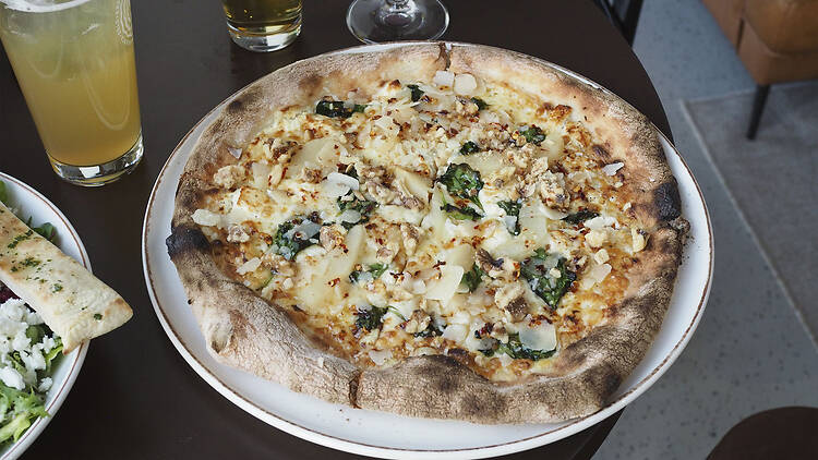 Pizza juustolla, päärynällä ja pähkinällä Varikko Panimossa Oulussa, pöydällä vaaleaa ja tummaa olutta laseissa.